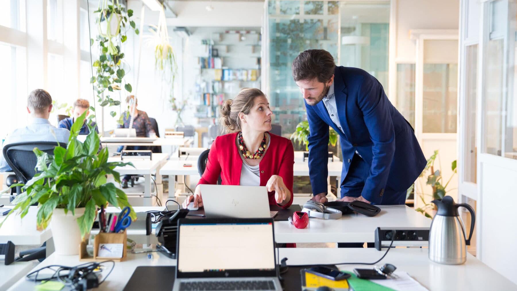 vrouw achter laptop, man naast haar aan het bureau, beeld van Copper8