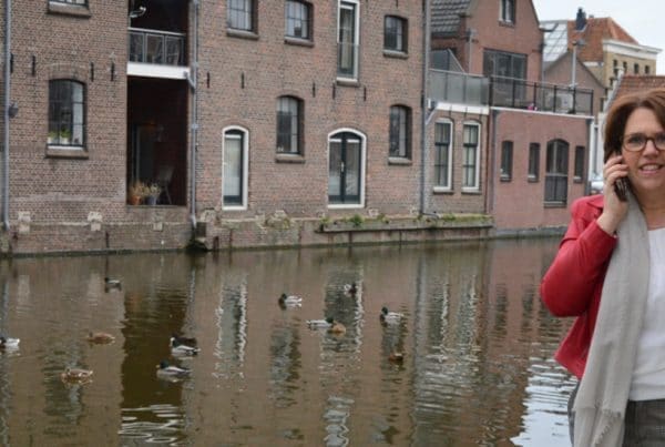 foto van bellende vrouw, ze loopt langs het water, links het logo van platform Groene Hart Werkt!